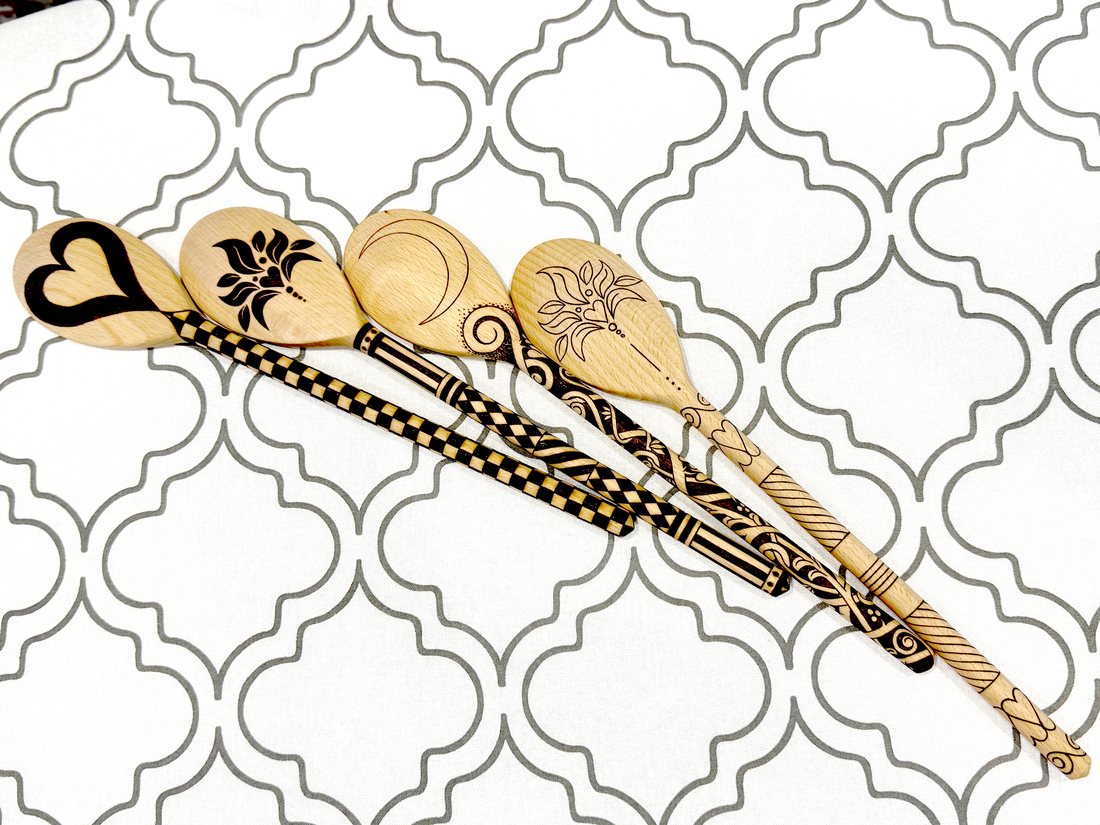 Two pyrography wooden spoons with moon and chequer designs
