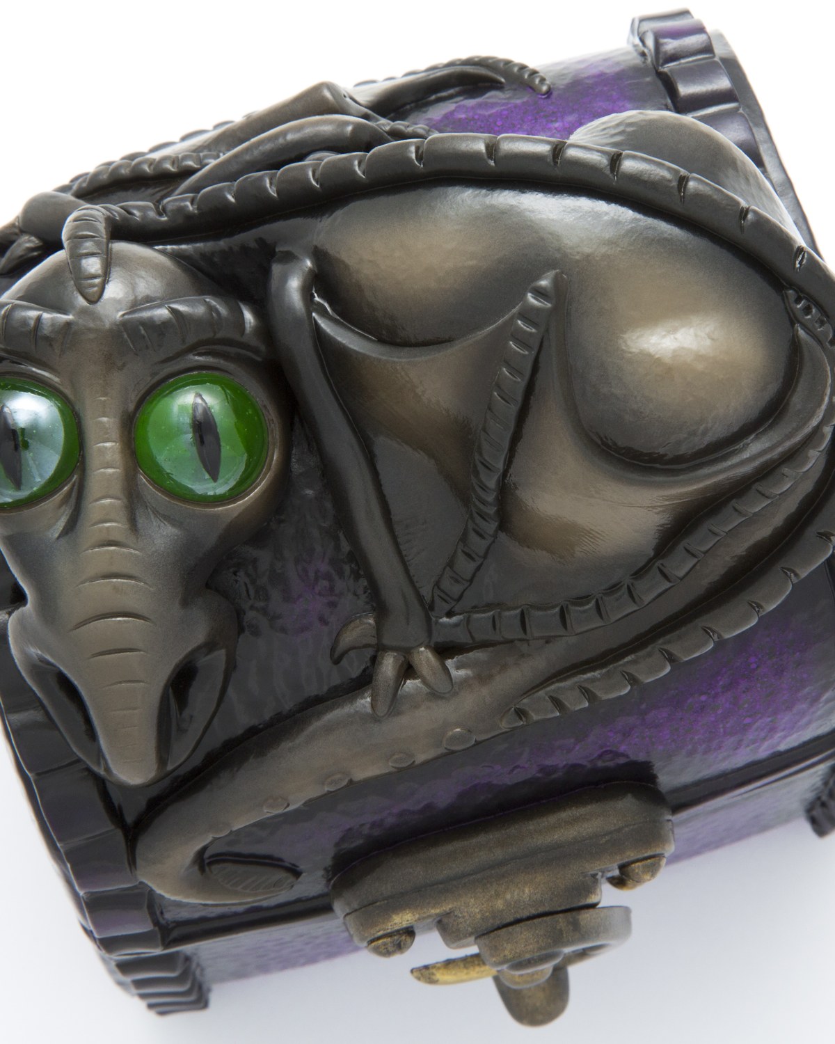 Small chest with a bronze dragon sculpted across the lid, curled around itself with green glass eyes