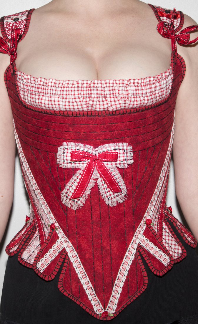 Front view of a handmade red gingham and ticking corset with a bow