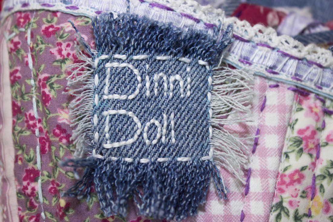 Close-up of the woven Dinni Doll label stitched into a corset
